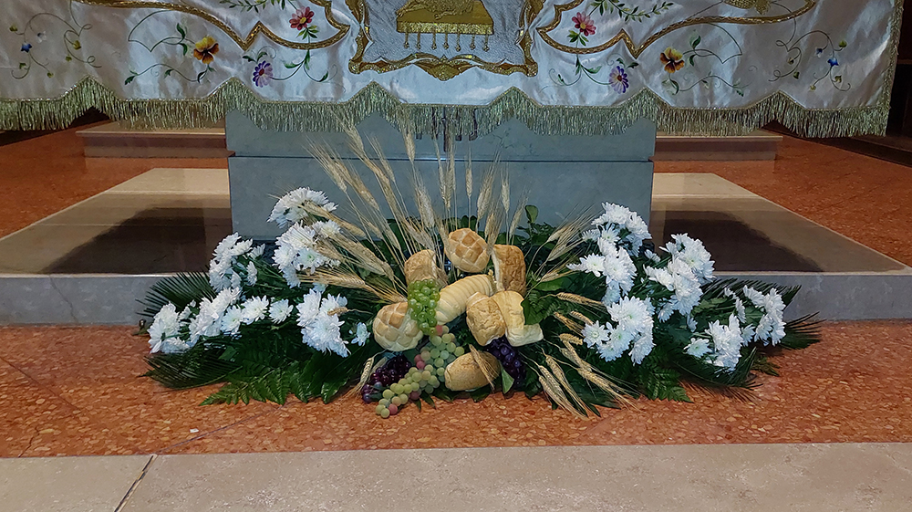 Composizione floreale da terra con margherite bianche e pane per cerimonia prima comunione