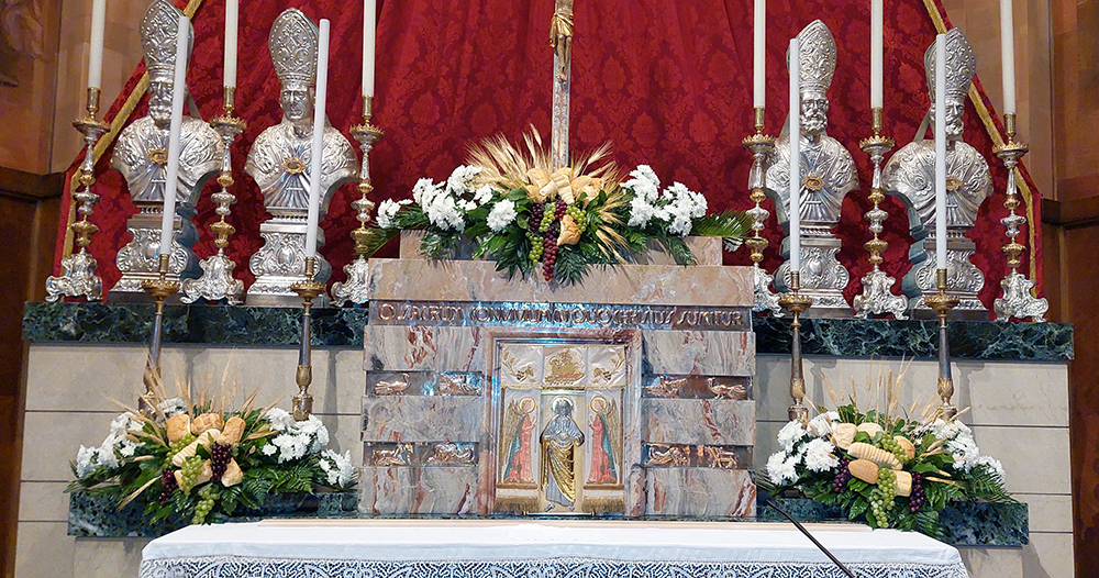 Altare addobbato con composizioni floreali composte da margherite bianche e pane per cerimonia prima comunione