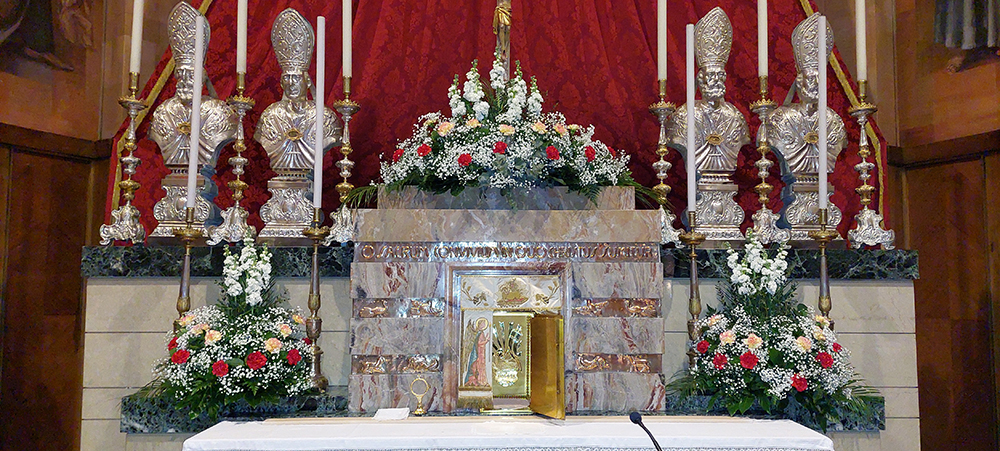 Altare con composizione di rose rosse e rose bianche velo da sposa e fiori centrali a grappolo